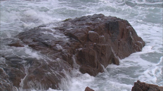 波浪冲刷着多岩石的海岸。视频素材