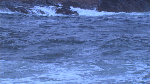 海浪拍打着布满岩石的海岸线。视频素材