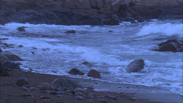 海浪拍打着布满岩石的海岸线。视频素材