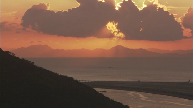 夕阳在天空中洒下橙色和金色的光。视频素材