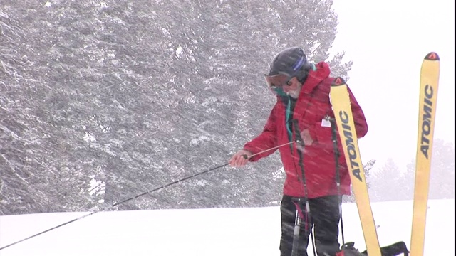 一名手持滑雪杖的救援人员将一只雪杖插入雪堆中。视频素材