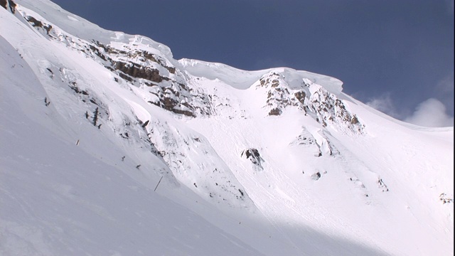 雪在雪山的山顶上吹起了一团雪。视频素材