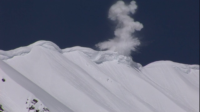 爆炸在山坡上引爆，试图引发有控制的雪崩。视频素材