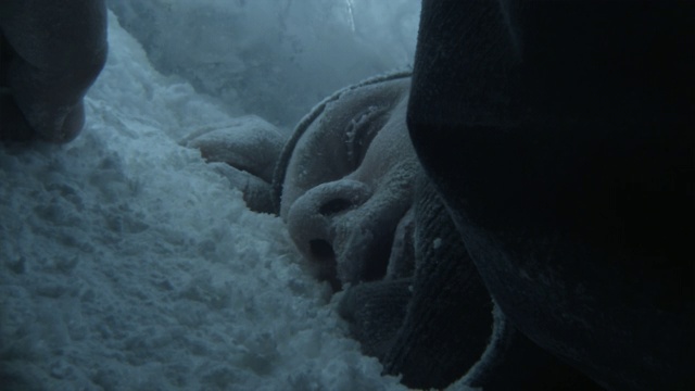 在巴塔哥尼亚的一场暴风雪中，一个寒冷的户外男子脸朝下躺在雪地里休息。视频素材