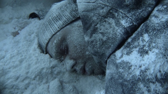 在巴塔哥尼亚的一场暴风雪中，一名脸冻住的男子在雪中休息。视频素材