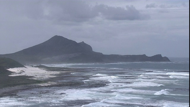 海浪滚向一个岛屿的海岸线。视频素材