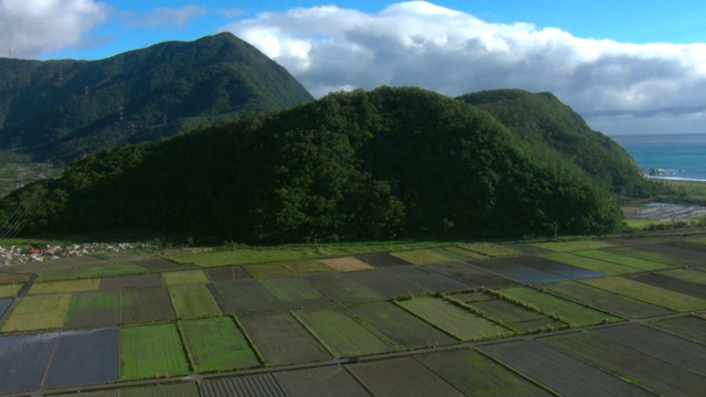 洪水部分淹没了树木繁茂的山区附近的沿海农田。视频素材