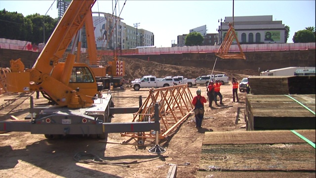 起重机在建筑工地吊起金属框架。视频素材