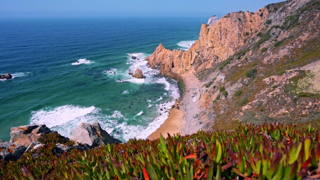 Praia do Ursa海滩的4k镜头与美丽的橙色悬崖和树叶在前景。葡萄牙，大西洋沿岸著名的旅游胜地卡波达罗卡灯塔附近视频素材