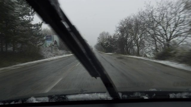 时间流逝。汽车POV在积雪覆盖的路上行驶，先下起了雪。视频素材