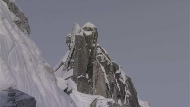 雪尘在阿拉斯加的冰川山峰上呈锯齿状。视频素材