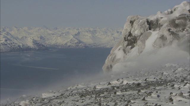 风在峡湾上方的山坡上吹雪。视频素材