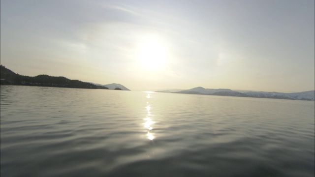 日落时，阳光反射在荒野峡湾平静的水面上。视频素材