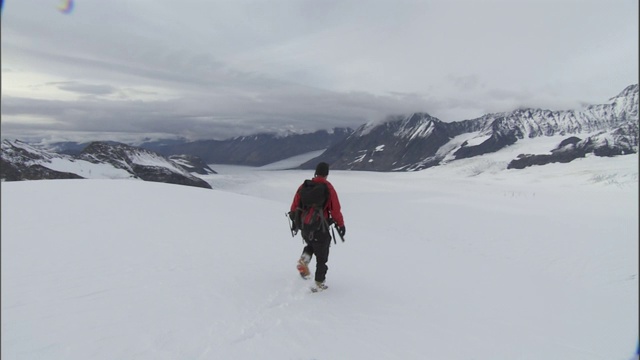 一个徒步旅行者在深雪中行走。视频素材