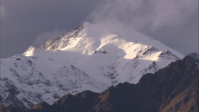 缕缕的云在雪山上飘过。视频素材