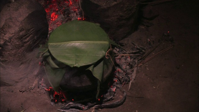 一个年轻人在小屋里准备其他食物，水壶里的蒸汽滚滚而出。视频素材