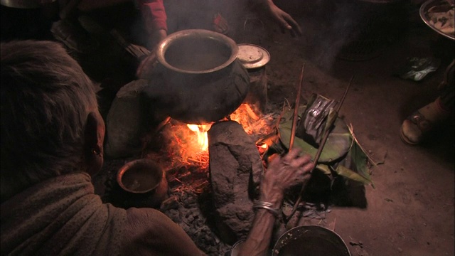 当地人坐在他们小屋的地板上做饭。视频素材