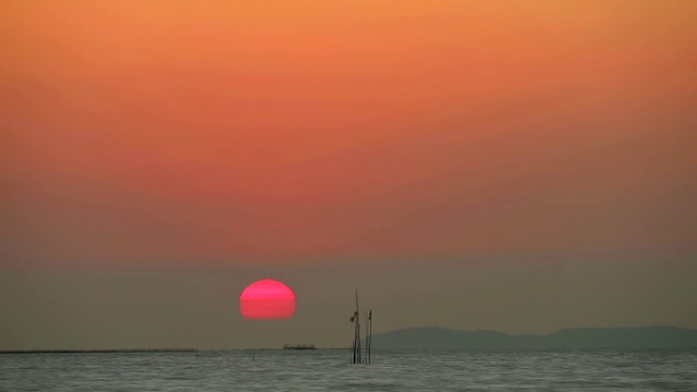 夕阳红色的天空下背黑云和渔船流逝的时间流逝视频素材