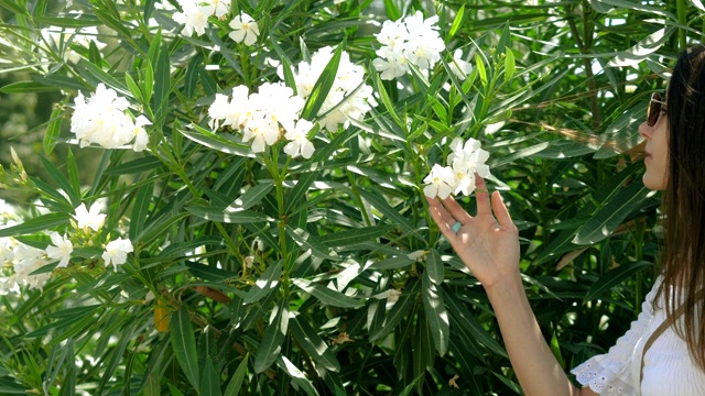 在巴塞罗那城堡公园，一位迷人的年轻女子深深地吸着花香。西班牙4 k。视频素材