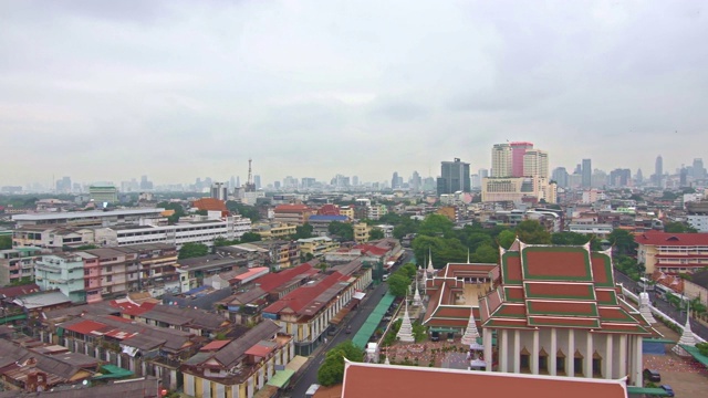 看看泰国曼谷市。前景为住宅楼，背景为摩天大楼的城市景观。现代建筑和佛教寺庙。视频素材