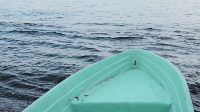 一艘渔船在海边，平静的海面与小波浪的背景视频素材