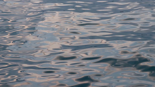 夏天日落时海面平静，水面上反射着太阳的小波浪视频素材