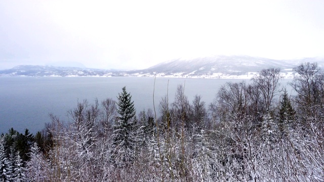 冬季挪威的风景与湖泊和雪山期间下雪视频素材