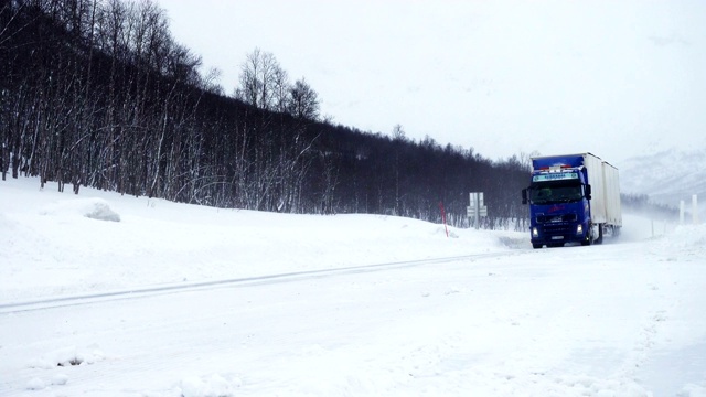 大雪期间，卡车行驶在被雪覆盖的光滑道路上视频素材