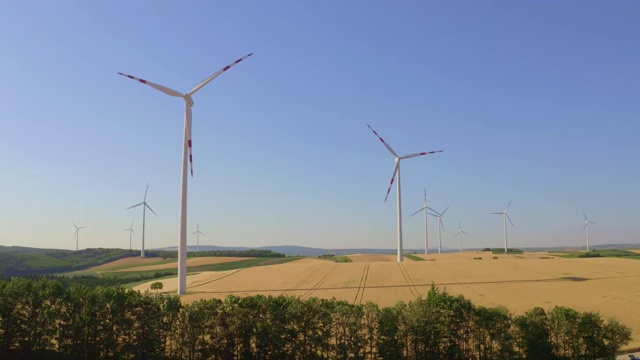 空中的风力涡轮机在金黄色的麦田里视频素材