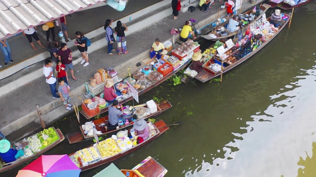 泰国Ratchaburi区Damnoen Saduak水上市场，当地人在船上出售水果、食物和纪念品的鸟瞰图。亚洲著名旅游景点。视频素材