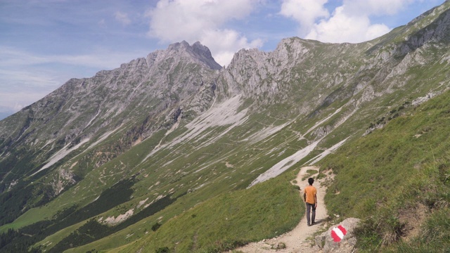 奥地利因斯布鲁克卡温德尔山，年轻的旅行者在奥地利阿尔卑斯山的斜坡上行走视频素材