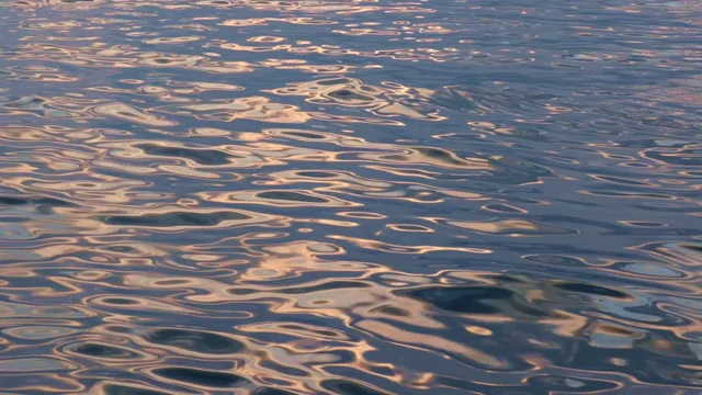 夏天日落时海面平静，水面上反射着太阳的小波浪视频素材