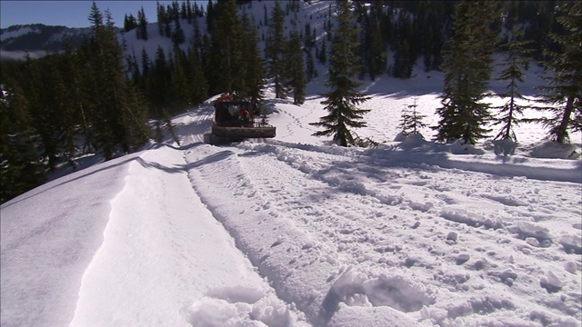 扫雪机在多雪的山坡上行驶。视频素材