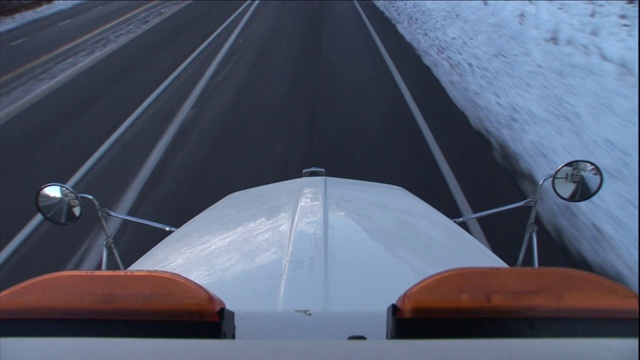 一辆卡车和其他车辆一起行驶在积雪的公路上。视频素材