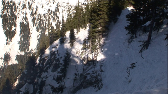 一场爆炸将泥土和碎石从积雪的山坡上抛下。视频素材