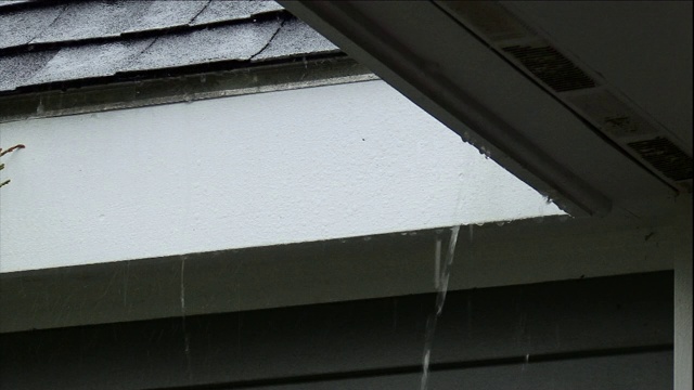 雨从建筑物的屋檐倾泻而下。视频素材