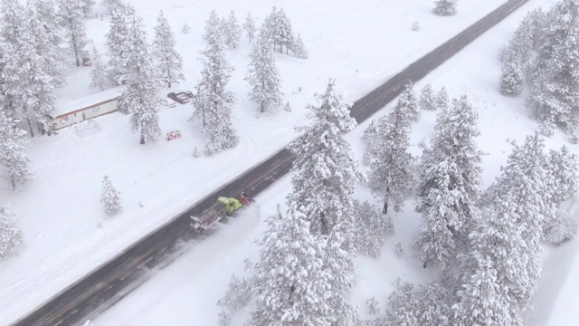 铲雪车清理穿过森林的乡村公路。视频素材