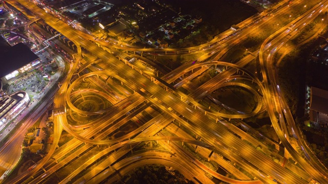 在高速公路路口驾驶的汽车鸟瞰图的超延时。桥梁道路形状的数字8或无限符号联系建筑的概念。前视图。曼谷夜市，泰国。视频素材