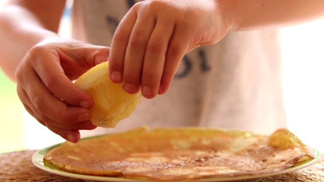 孩子用手把柠檬挤进食物盘里视频素材