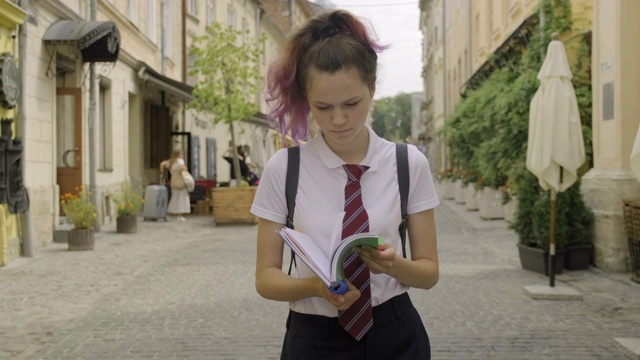 漂亮的学生少女笔记本。女性在户外读书视频素材