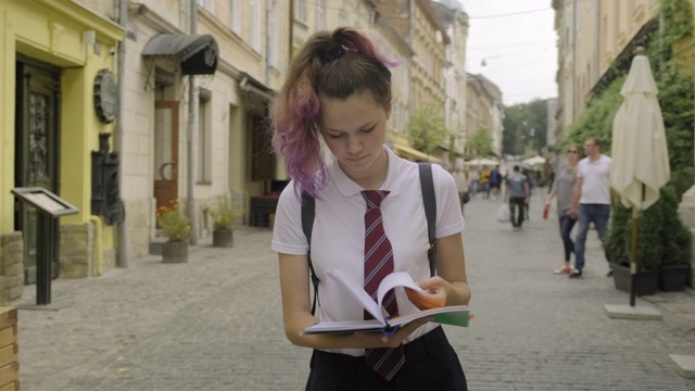 漂亮的学生少女笔记本。女性在户外读书视频素材