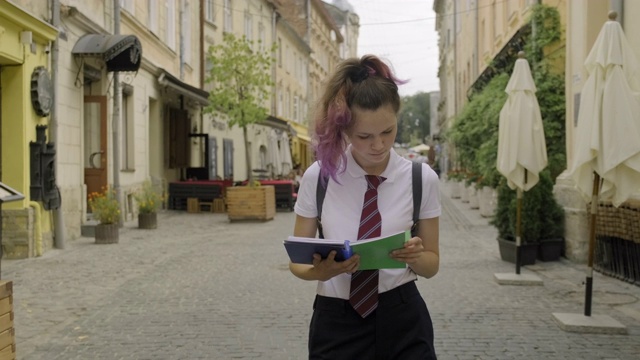 漂亮的学生少女笔记本。女性在户外读书视频素材