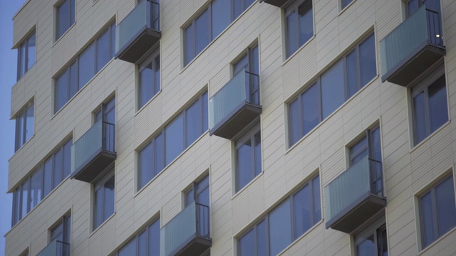 近景现代住宅建筑。住宅建筑外部以蓝天为背景。该建筑的外部设有小阳台视频素材