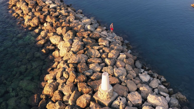 鸟瞰地中海和码头或石头码头或防波堤日落时，无人机拍摄视频素材