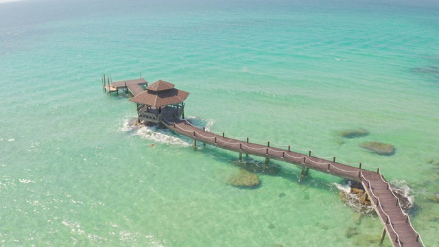 鸟瞰图的木制酒吧在海上和小屋与晴朗的天空和海滩在Koh Kood在Trat，泰国。暑假，旅游，假期和假期。在海上放松和旅行的概念。视频素材