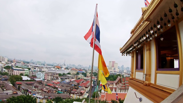 泰国曼谷的萨吉寺。带有钟声的寺庙屋顶细节视图。一面有佛教旗帜的泰国国旗。著名精神的地方。广泛的观点。视频素材