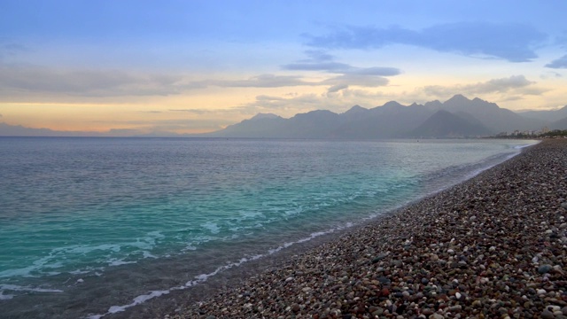 日落在安塔利亚著名的老城Konyaaltı海滩和海湾山。视频素材