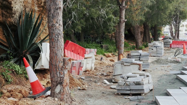 公路正在建设之中。街道重建与道路混凝土瓷砖和路障与交通锥。重建道路受阻。视频素材