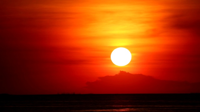 日落在红橙色的天空上，在浅橙色的云和黑暗的海时间流逝视频素材