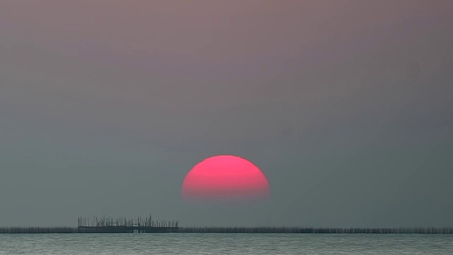 日落在晴朗的天空在浅橙色的云在海上时间流逝视频素材